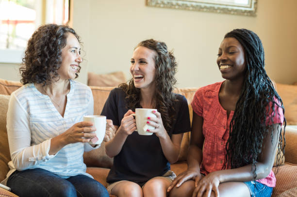 istock Three girlfriends enjoying tea and conversation together in the living room 954896332