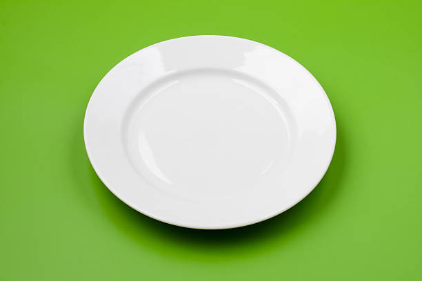 istock White round plate on green background 95490390
