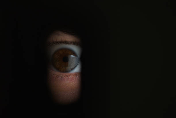 oeil humain à la recherche de throuht un trou de serrure - keyhole peeking human eye curiosity photos et images de collection