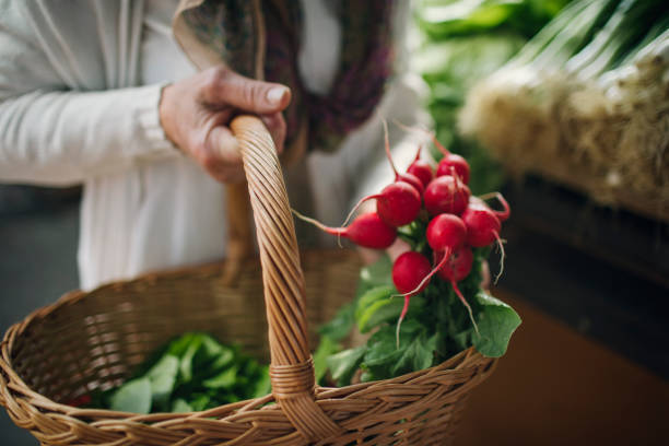 Senior woman at greengrocer's shopping for fresh fruits and vegetables