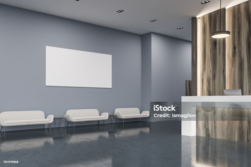 Wooden reception in office waiting room, poster White and wooden reception desk with two computers on it in a modern gray and wooden wall office with a concrete floor. Sofas and a poster. 3d rendering mock up Computer Monitor Stock Photo