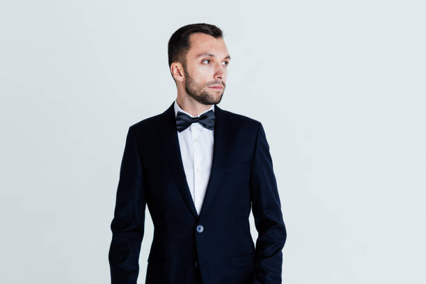 istock Stylish young man in black suit and bow tie 954920096