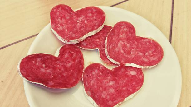 istock Slices of heart-shaped sausage on a plate 954920114