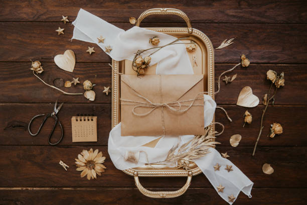 istock Empty greeting card with kraft envelope on wooden background. Wedding concept. Top view, flat lay 954922324