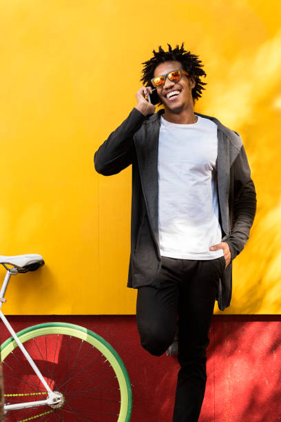 afro junger mann mit handy und fixed-gear fahrrad. - short cycle stock-fotos und bilder