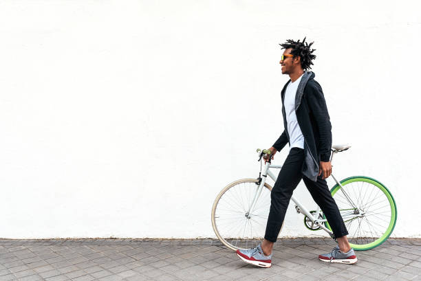 携帯電話と固定ギアの自転車を使用してハンサムな若い男。 - short cycle ストックフォトと画像