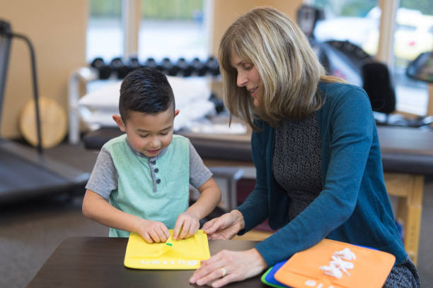 istock Occupational therapist works with a young ethnic boy 954923232