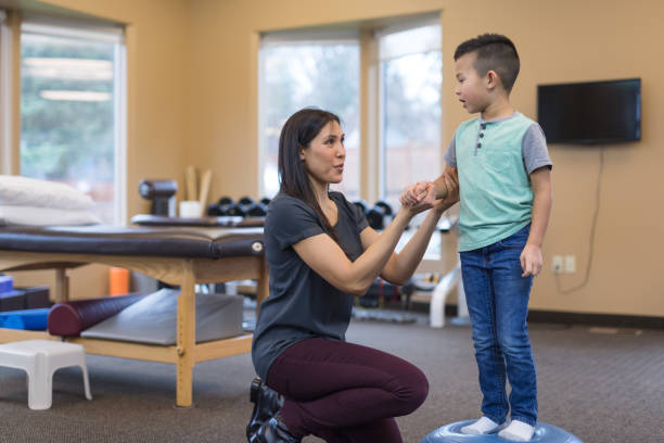 istock A physical therapist works with a young ethnic boy 954923240
