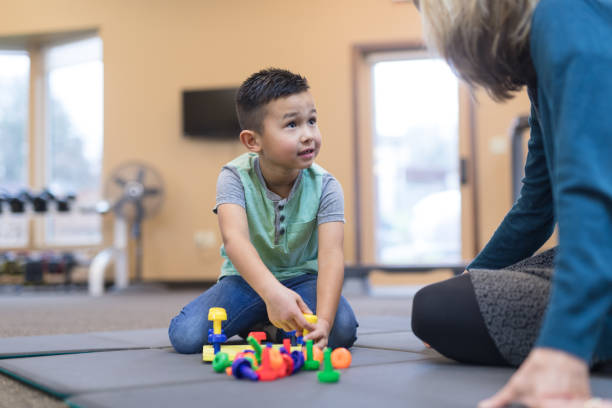 istock Occupational therapist works with a young ethnic boy 954923254