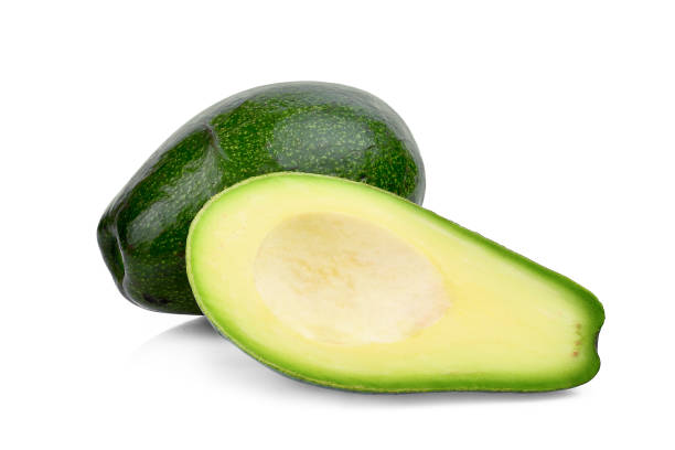 avocado intero e mezzo isolato su sfondo bianco - avocado cross section vegetable seed foto e immagini stock