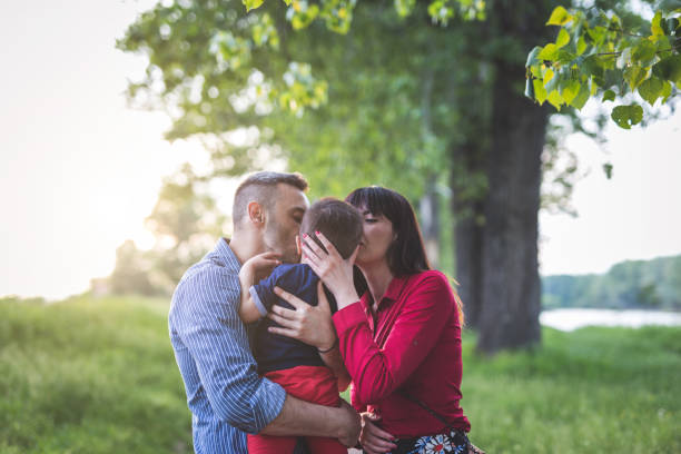 familia joven besándose - tree grass family human relationship family fotografías e imágenes de stock