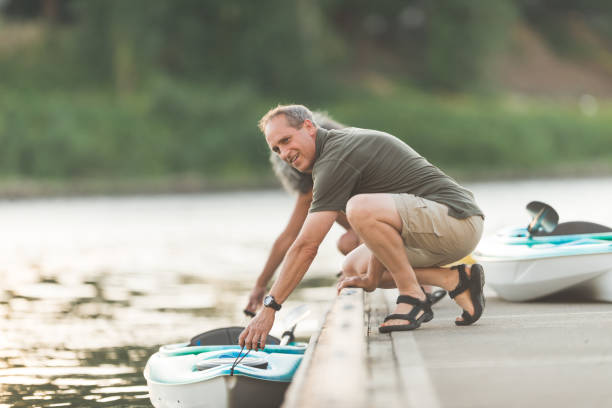 istock Senior couple stands on dock and gets ready to kayak 954927554
