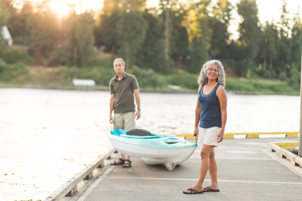 istock Senior couple stands on dock and gets ready to kayak 954927558
