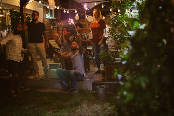 istock Friends Watching Sports On Big Screen In Backyard 954928796