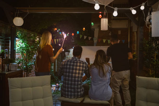istock Friends Watching Sports On Big Screen In Backyard 954928872