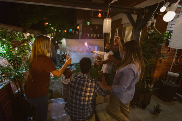 istock Friends Watching Sports On Big Screen In Backyard 954929236