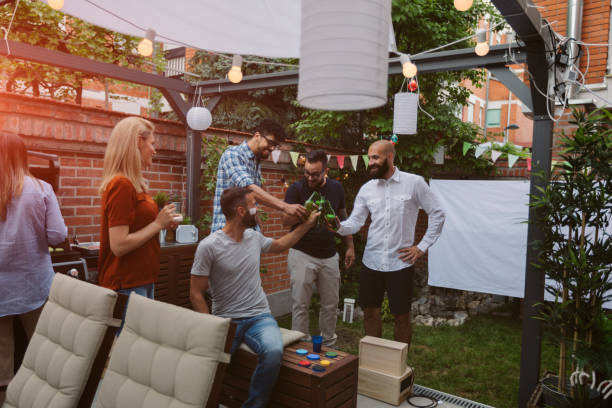 Friends Watching Sports On Big Screen In Backyard