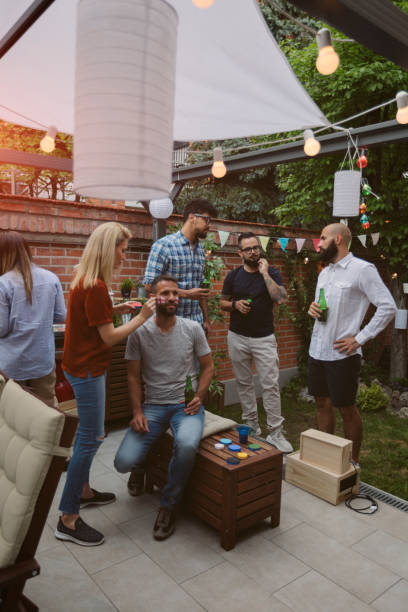 istock Friends Watching Sports On Big Screen In Backyard 954937014
