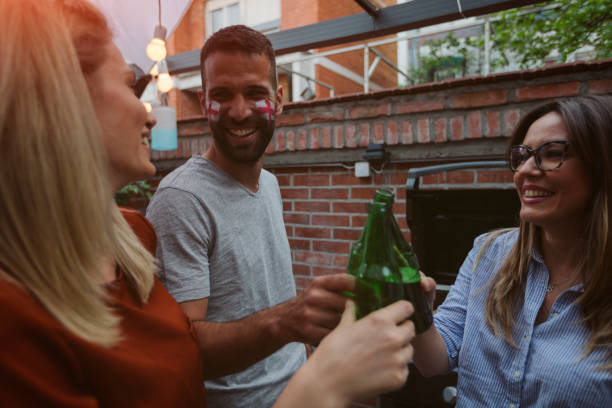 istock Friends Watching Sports On Big Screen In Backyard 954937158