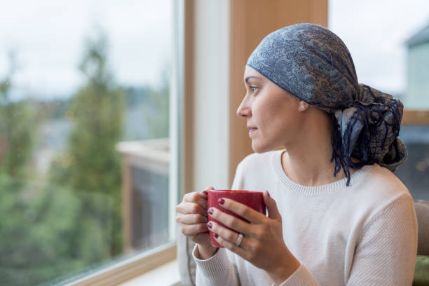 istock A middle-aged cancer survivor sits by the window and reflects on her life 954939886