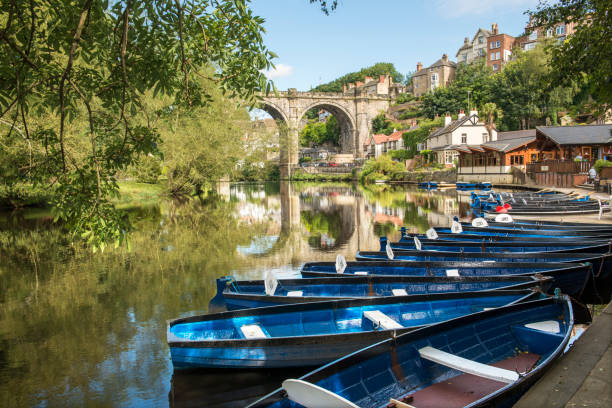 a number of rowing boats on a river at Knaresborough in North Yorkshire in summer near the viaduct