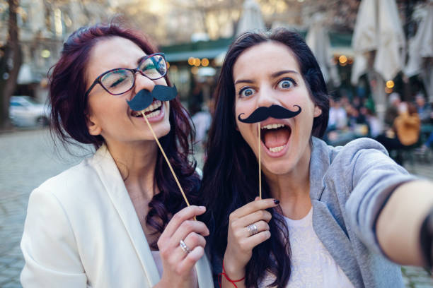istock Girlfriends making selfies with paper mustaches 954946610