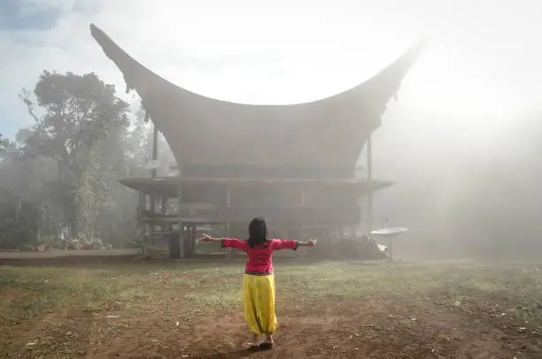 Photo of Beautiful Indonesian woman poses in front of Toraja Tongkonan house