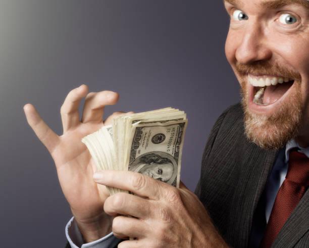 istock Delighted businessman counts his stack of money 954952382