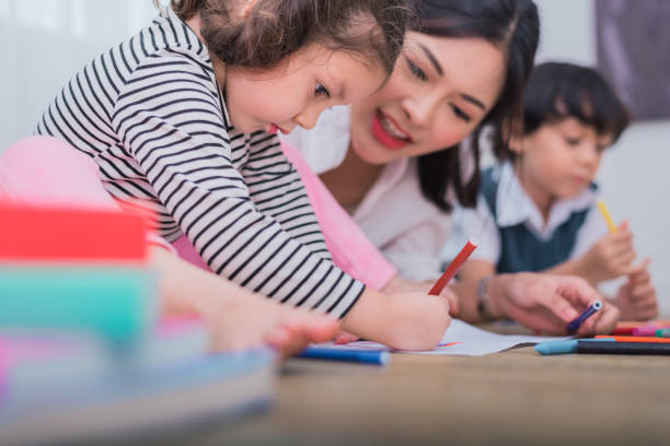 bambini carini e insegnante asiatici che disegnano in classe d'artista. torniamo al concetto di scuola e istruzione. tema asilo nido e prescolare. tema studente e sorellina. - preschooler preschool child painting foto e immagini stock