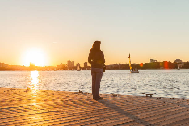 Woman looking at sunset on Charles River in Boston