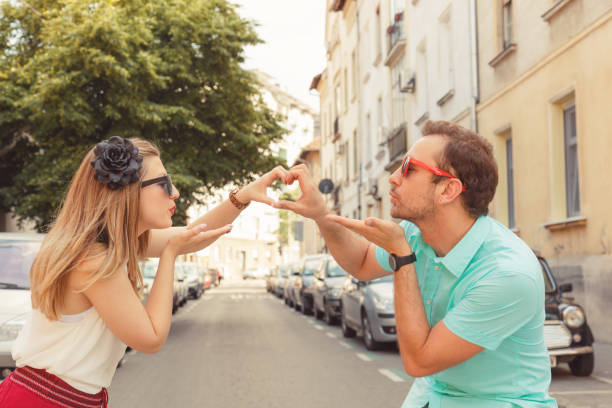 istock Couple in love making heart shape with hands. 954965886
