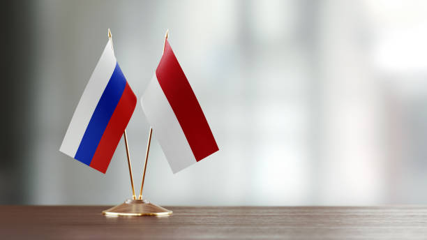 istock Russian And Indonesian Flag Pair On A Desk Over Defocused Background 954967614