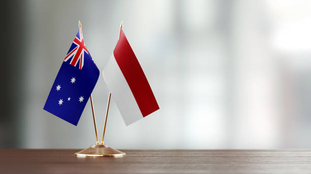 istock Australian And Indonesian Flag Pair On A Desk Over Defocused Background 954969762