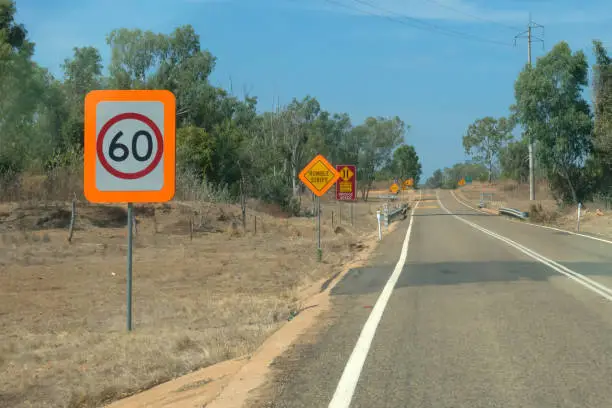 Photo of Speed restriction sign near road in the outback of Queensland in Australia