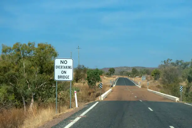 Photo of No overtaking on bridge sign near road in the outback of Queensland in Australia