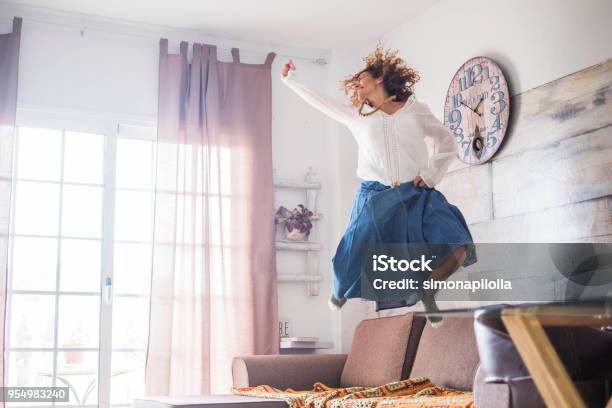 Beautiful Caucasian Woman Jump At Home Stock Photo - Download Image Now - Happiness, Domestic Life, One Woman Only