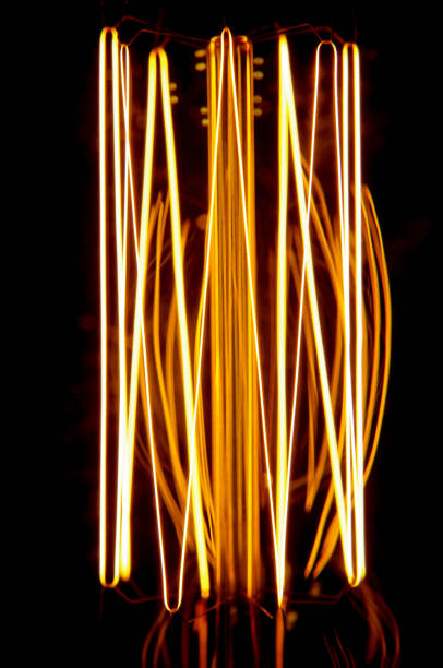 istock Glowing vintage lamp filament isolated on the dark background 954983428