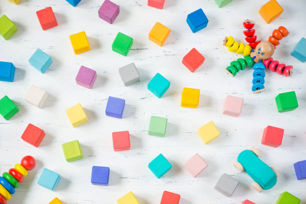 istock Kids toys frame (wooden blocks, octopus, car, pyramidion) on white wooden background. Top view. Flat lay. 954983712