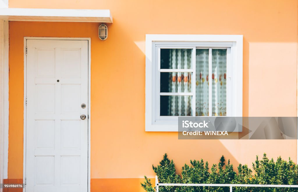 Front of resort with door and window on green background Front of resort with door and window on light orange backgroundFront of resort with door and window on green background House Stock Photo