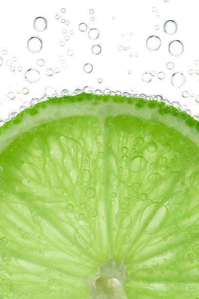 istock Lime slice with bubbles in water isolated on white background 954988220
