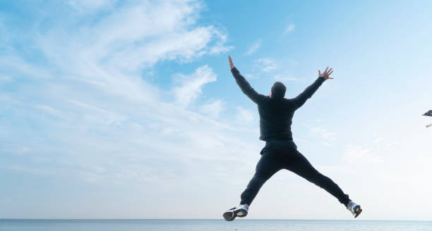 istock Man Jumping And Spreading Arms And Legs 954992706