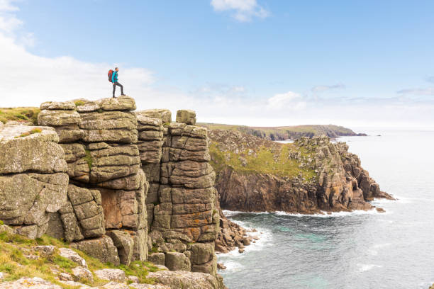 istock Man standing on a rock cliff enjoying the view 954993028