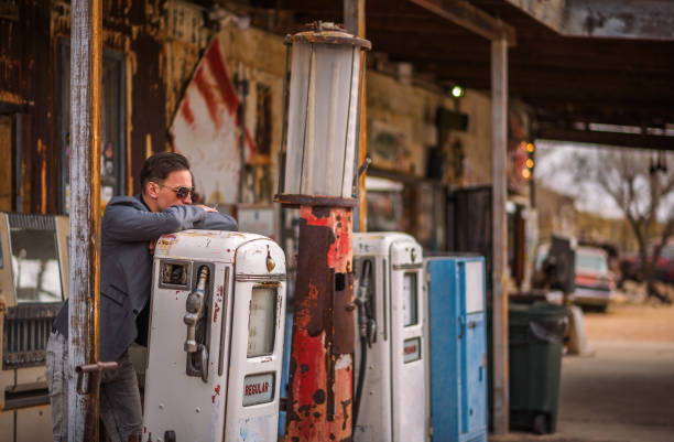 istock Young man smokes a cigarette at a vintage gas pump 955000288