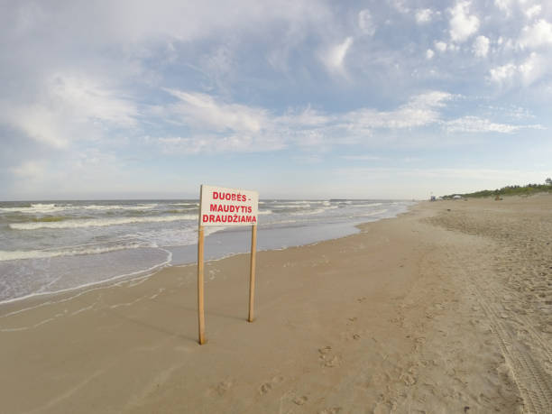 istock Sign of bathing prohibition in the empty Palanga beach. Text 955009630