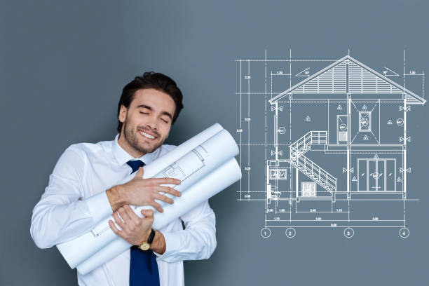 Positive architect hugging the schemes after finishing his favorite project