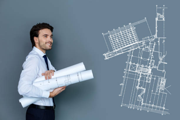 istock Happy young engineer smiling while carrying graphics to his colleagues 955011798