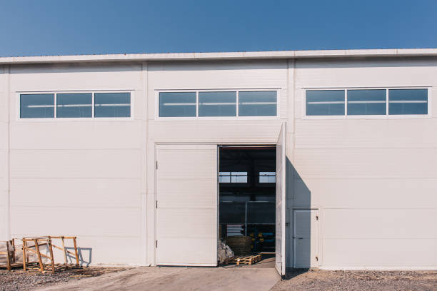 istock Large industrial warehouse or storehouse exterior with open gates 955014316