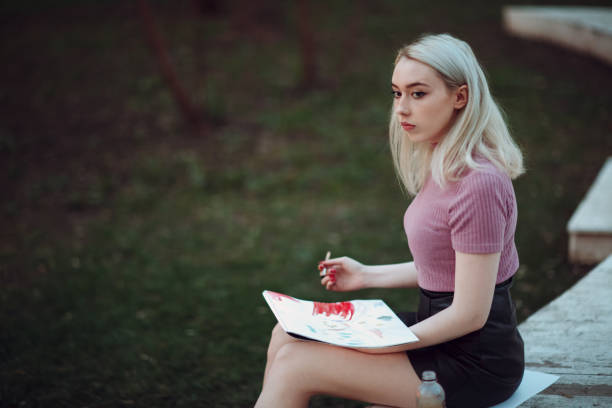 istock Young pretty girl painter draw in park 955023632