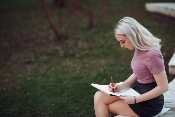 istock Young pretty woman painter draw in park 955023696