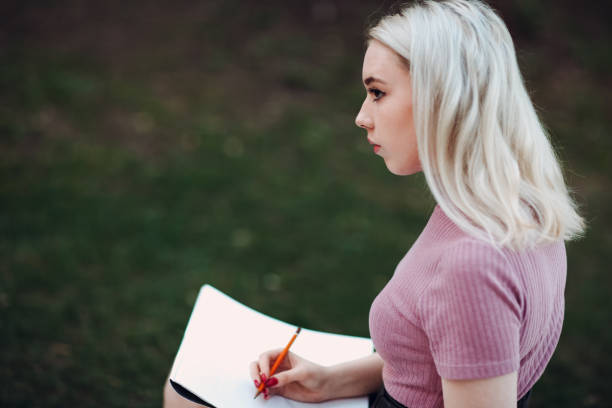 istock Young pretty woman painter draw in park 955023730